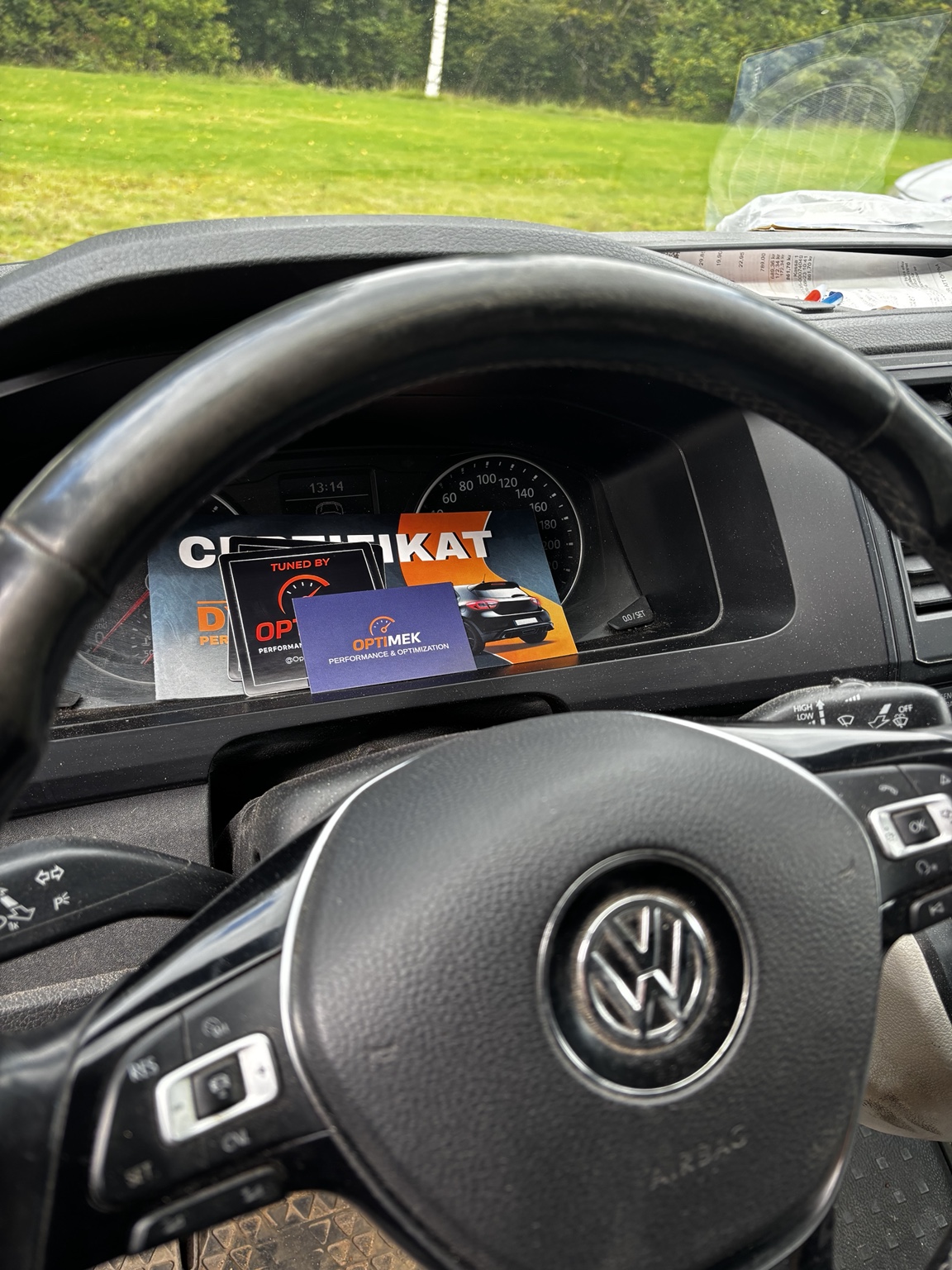 OptiMek visitkort och material i en Volkswagen